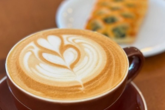 Three portafilters showing whole beans, ground coffee, and a finished latte with latte art