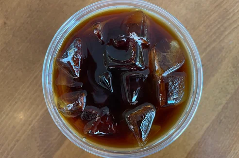 Overhead view of iced coffee with ice cubes in a clear cup