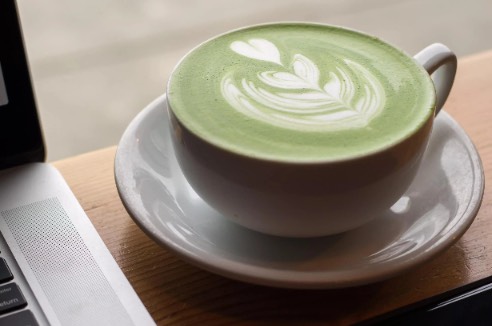 Matcha latte beside a laptop
